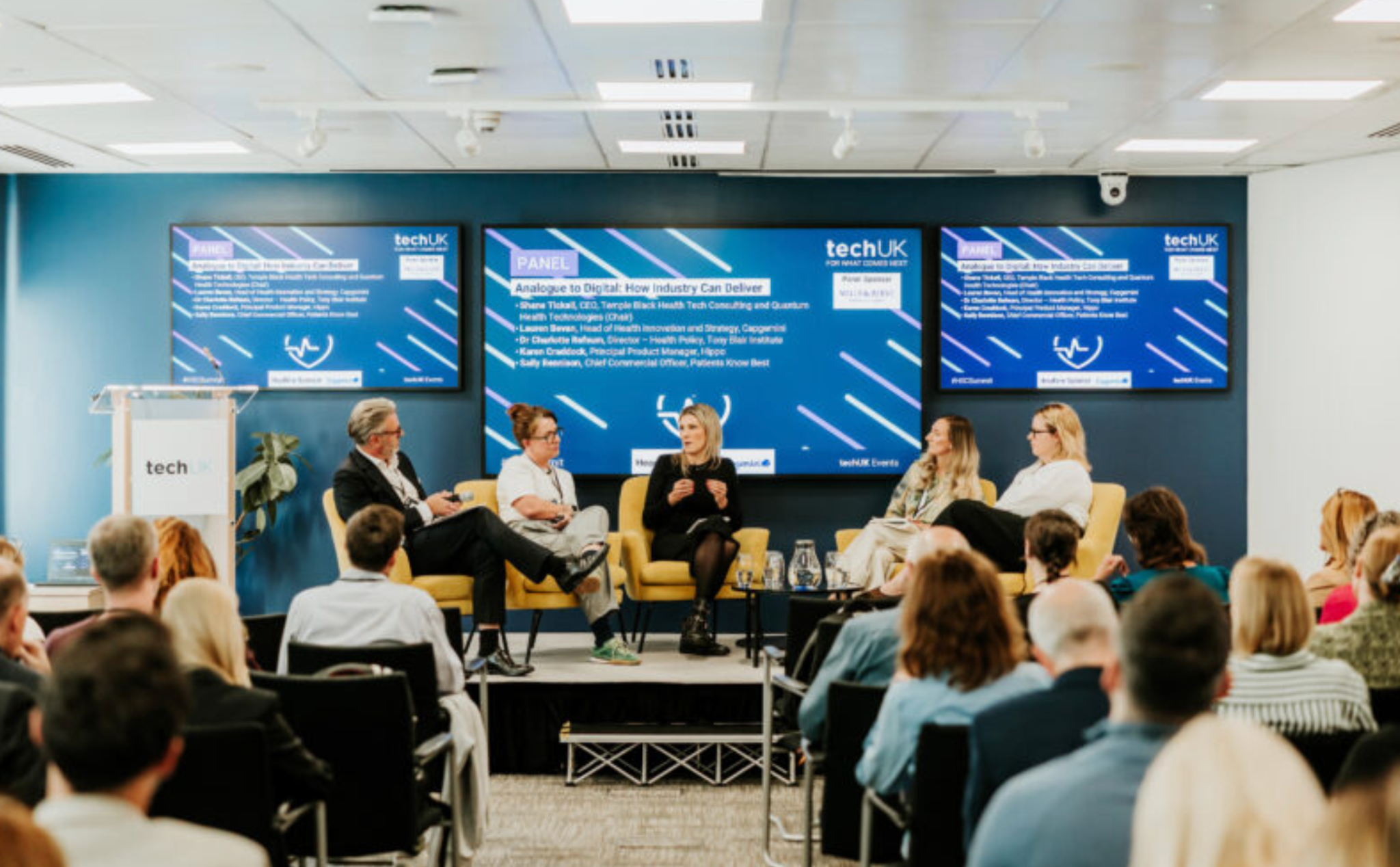 Panellists speaking to an audience at a techUK event
